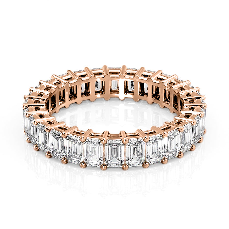 4ct Emerald Eternity. A Rose Gold Eternity Ring Set With 4tcw Emerald Lab Grown Diamonds. White Background.