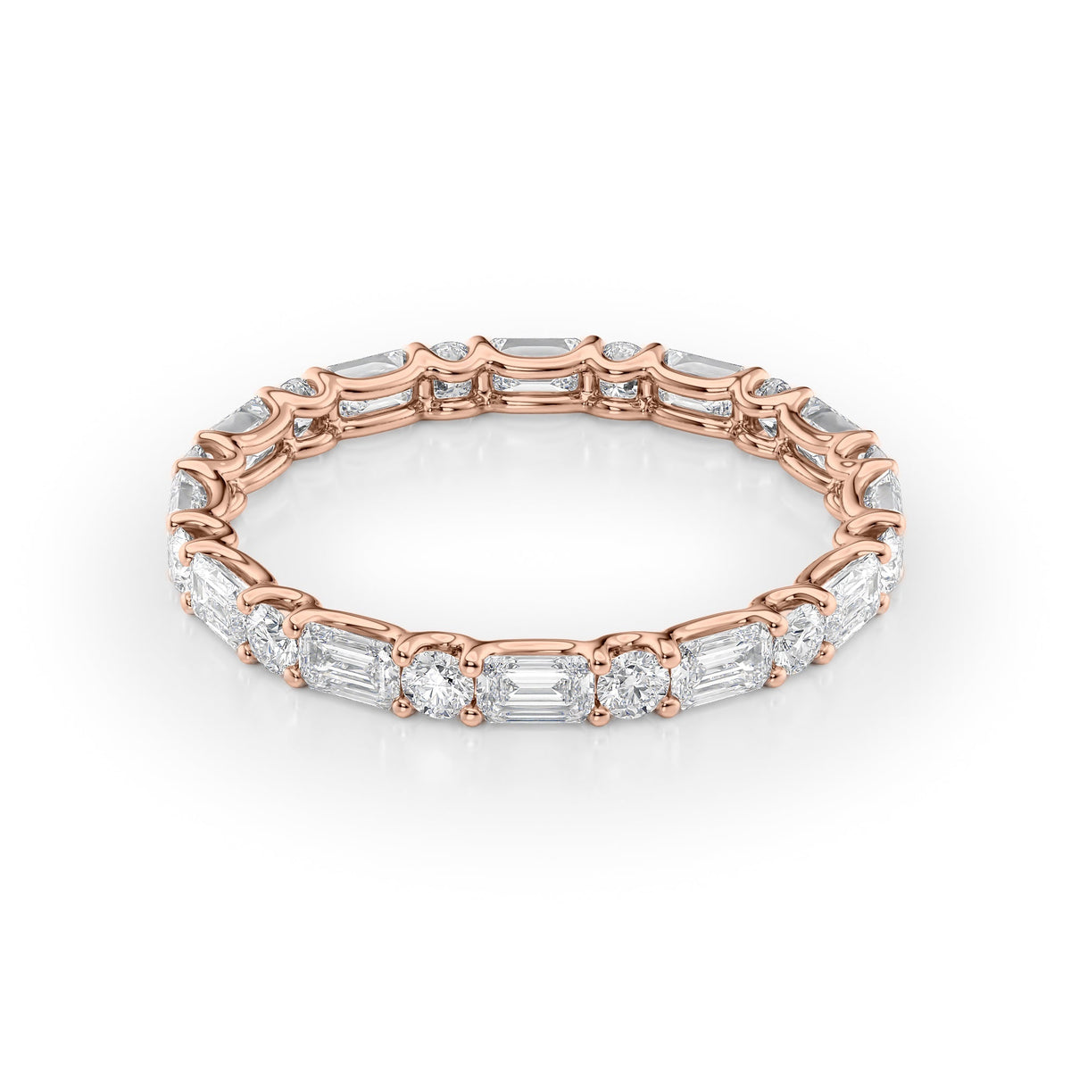1.5ct Alternating Emerald And Round U Prong Eternity. A Rose Gold Eternity Ring Set With 1.3tcw Emerald Lab Grown Diamonds. White Background.
