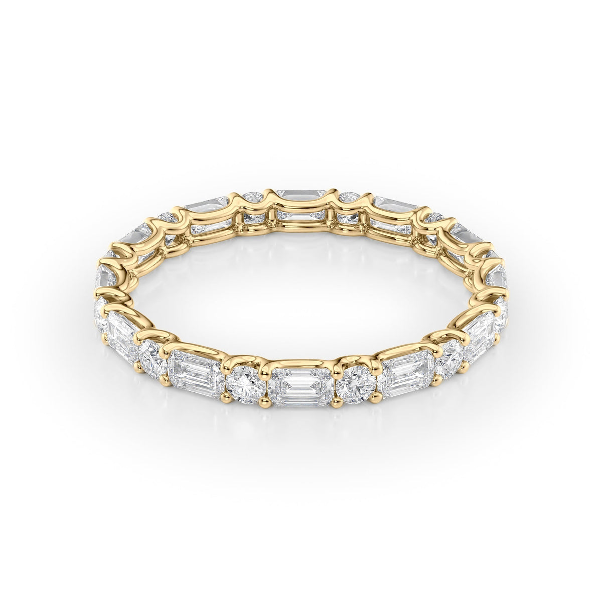 1.5ct Alternating Emerald And Round U Prong Eternity. A Yellow Gold Eternity Ring Set With 1.3tcw Emerald Lab Grown Diamonds. White Background.