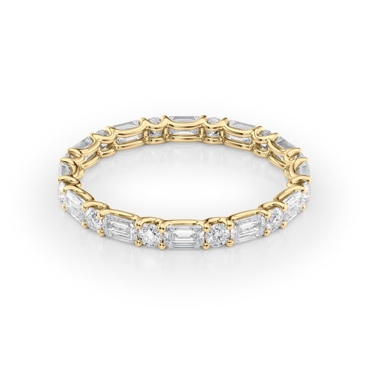 1.5ct Alternating Emerald And Round U Prong Eternity. A Yellow Gold Eternity Ring Set With 1.3tcw Emerald Lab Grown Diamonds. White Background.