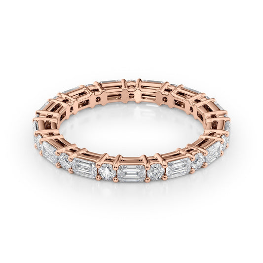 1.7ct Alternating Emerald And Round Basket Eternity. A Rose Gold Eternity Ring Set With 1.3tcw Emerald Lab Grown Diamonds. White Background.