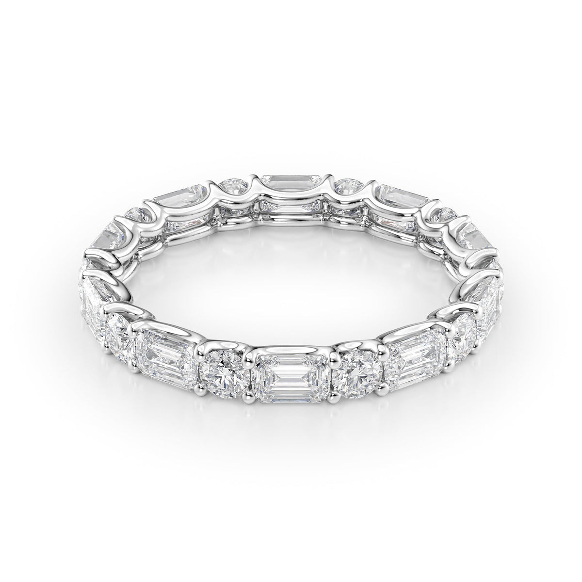 2.6ct Alternating Emerald And Round U Prong Eternity. A White Gold Eternity Ring Set With 2tcw Emerald Lab Grown Diamonds. White Background.