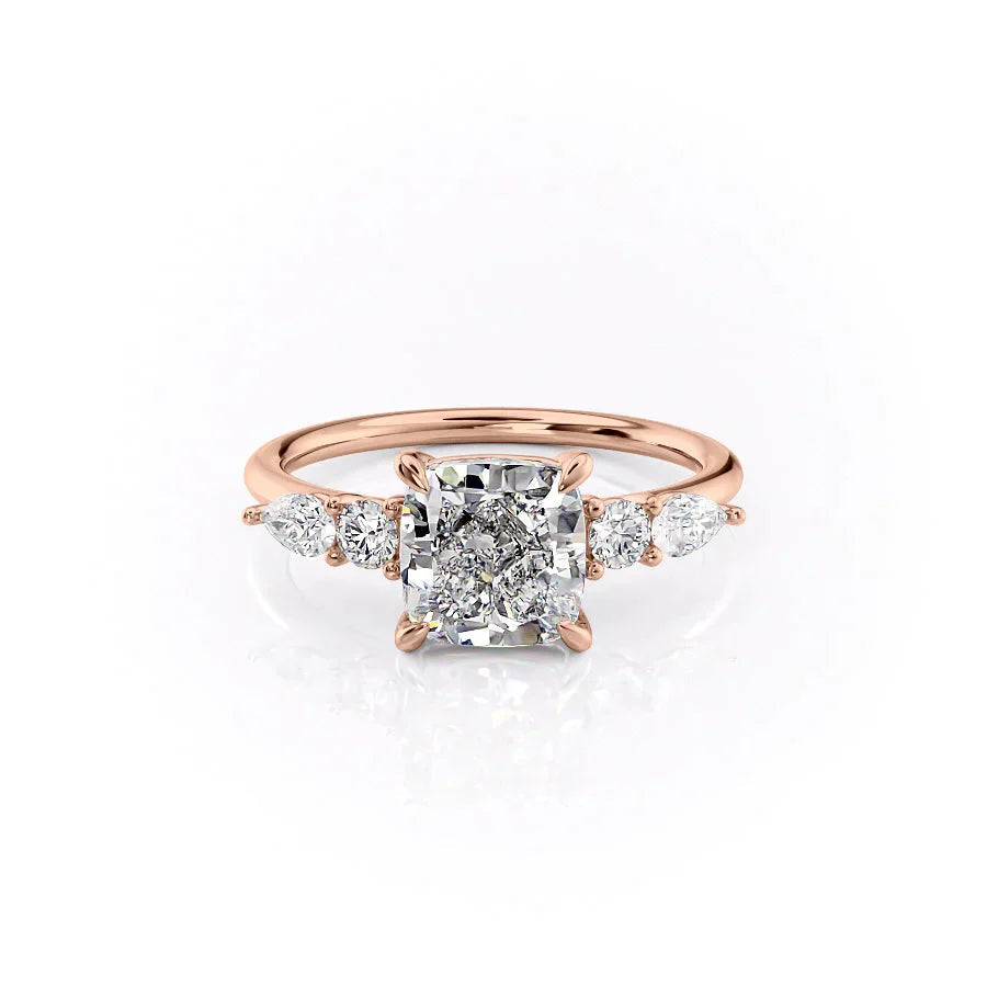 The Abigail. A Rose Gold Three Stone, Side Stones Engagement Ring Set With A 2ct Cushion Lab Grown Diamond. White Background.
