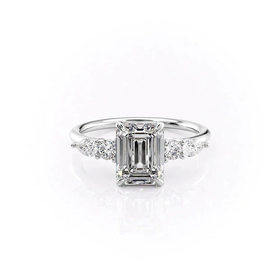 The Abigail. A White Gold Three Stone, Side Stones Engagement Ring Set With A 2ct Emerald Lab Grown Diamond. White Background.