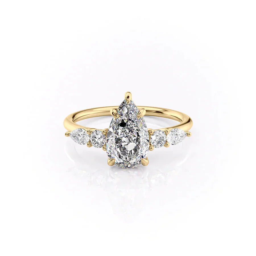The Abigail. A Yellow Gold Three Stone, Side Stones Engagement Ring Set With A 2ct Pear Lab Grown Diamond. White Background.