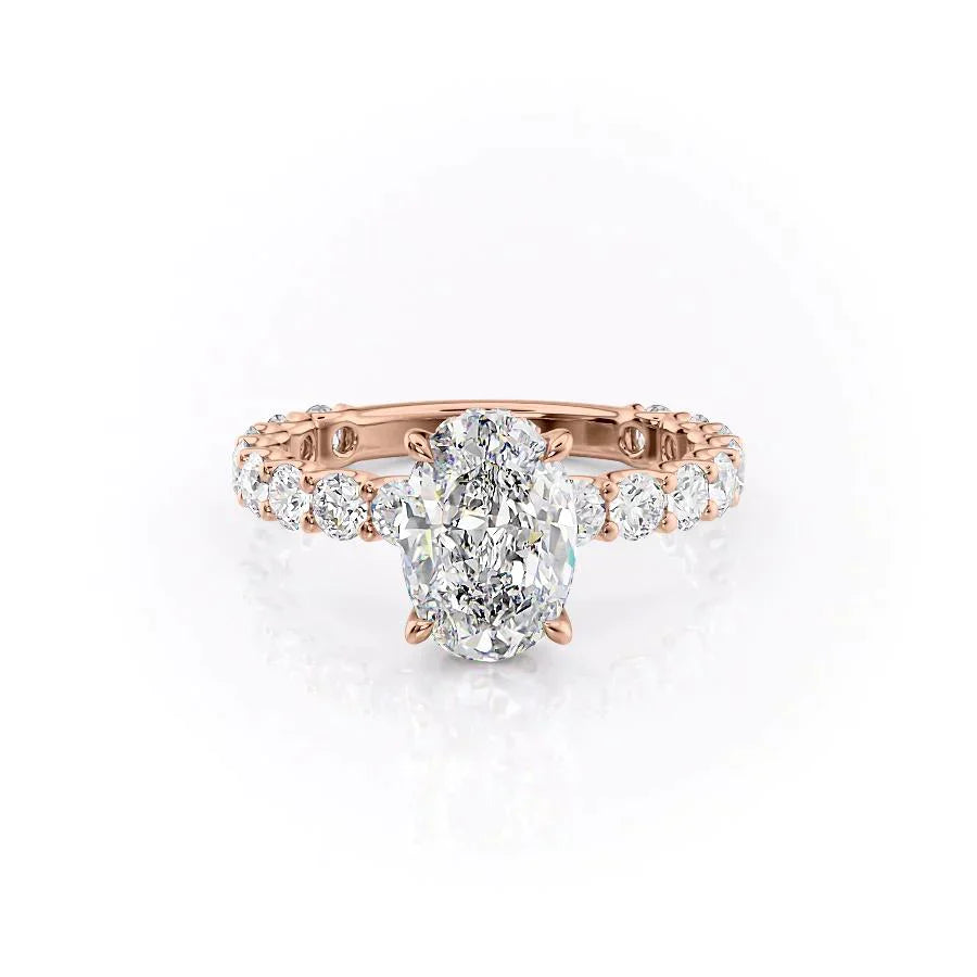 The Adelle. A Rose Gold Side Stones, Hidden Halo Engagement Ring Set With A 2ct Oval Lab Grown Diamond. White Background.