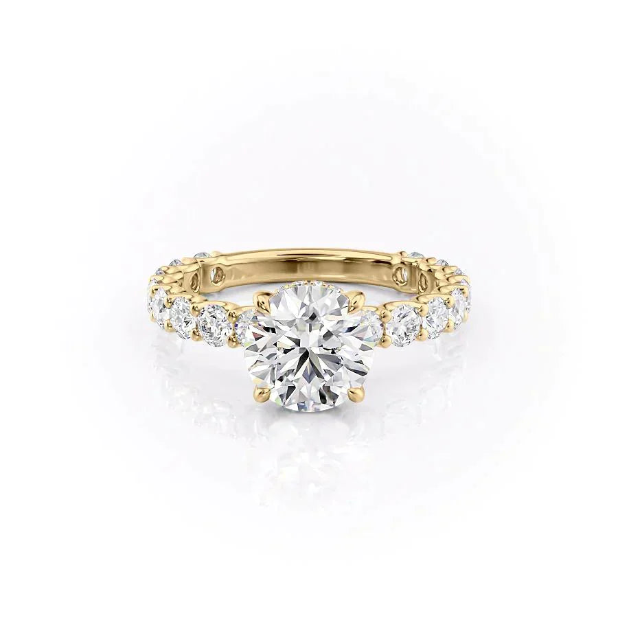 The Adelle. A Yellow Gold Side Stones, Hidden Halo Engagement Ring Set With A 2ct Round Lab Grown Diamond. White Background.