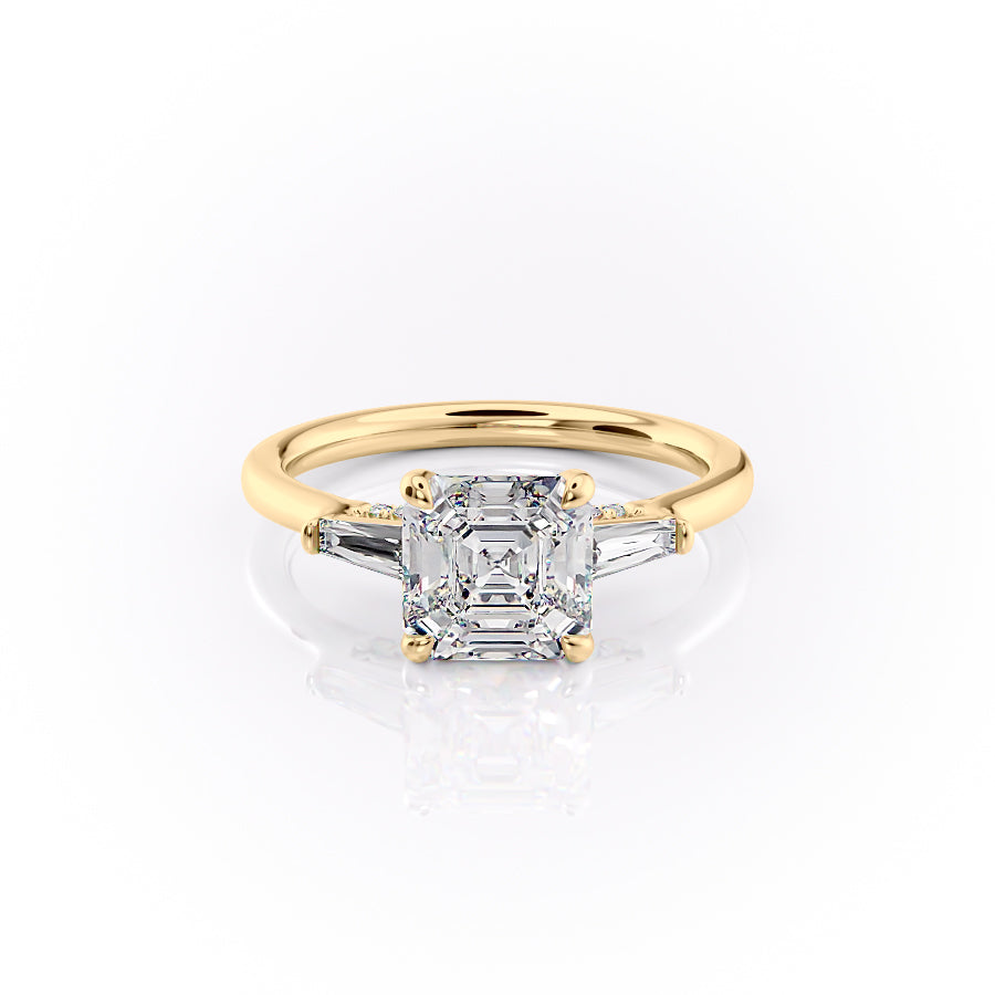 The Baguettes Megan. A Yellow Gold Three Stone Engagement Ring Set With A 2ct Asscher Lab Grown Diamond. White Background.