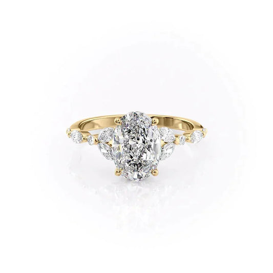 The Chelsea. A Yellow Gold Side Stones, Three Stone Engagement Ring Set With A 2ct Oval Lab Grown Diamond. White Background.