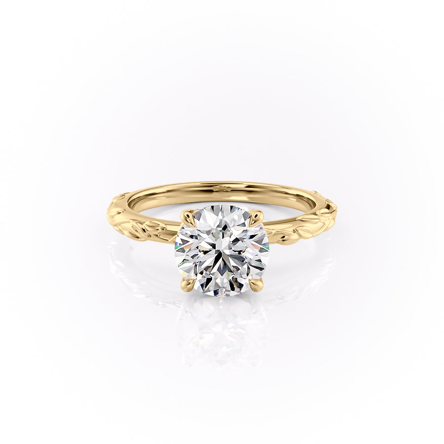 The Flora. A Yellow Gold Nature, Solitaire Engagement Ring Set With A 2ct Round Lab Grown Diamond. White Background.