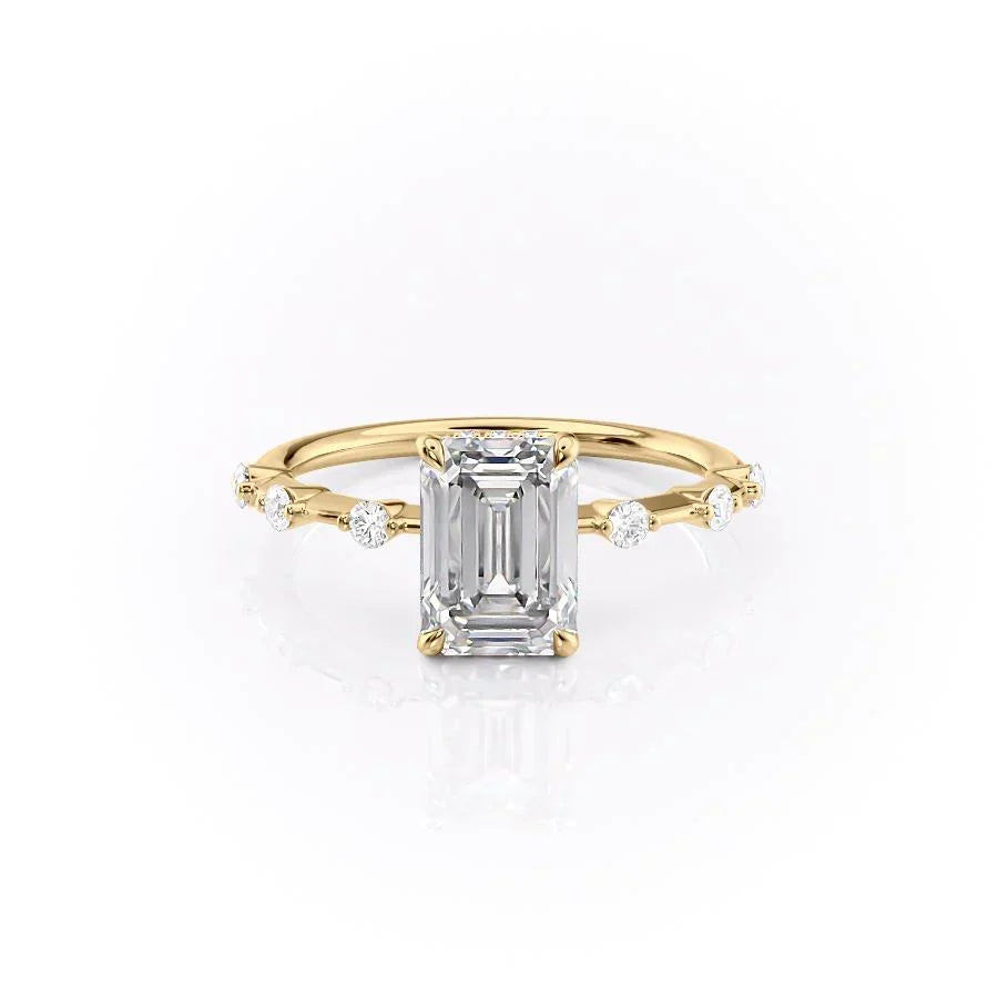 The Hidden Halo Penelope. A Yellow Gold Side Stones Engagement Ring Set With A 2ct Emerald Lab Grown Diamond. White Background.