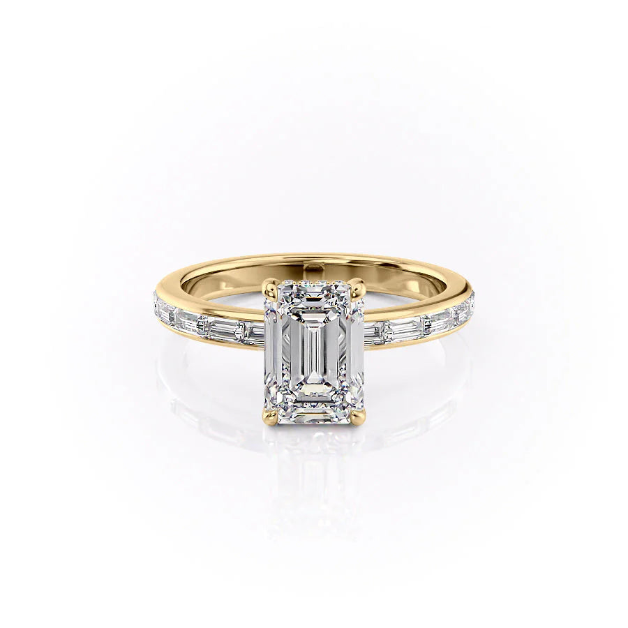 The Jennifer. A Yellow Gold Channel-Set, Side Stones, Hidden Halo Engagement Ring Set With A 2ct Emerald Lab Grown Diamond. White Background.