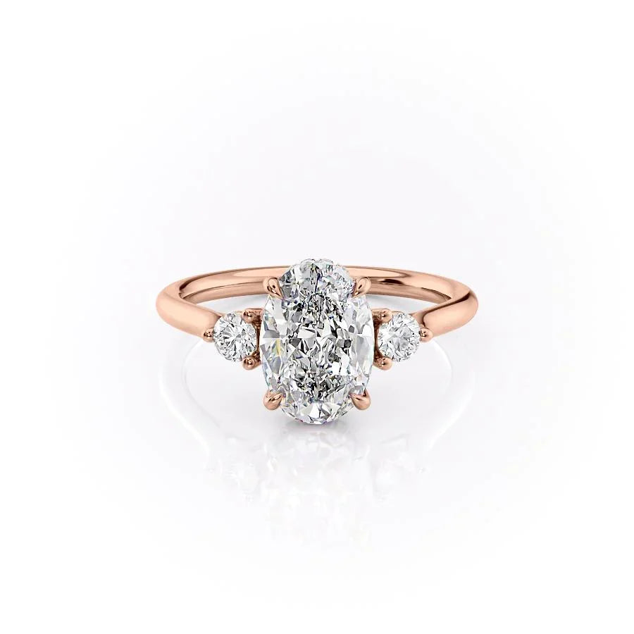 The Lia. A Rose Gold Three Stone Engagement Ring Set With A 2ct Oval Lab Grown Diamond. White Background.