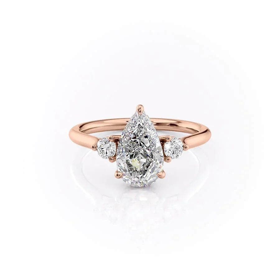 The Lia. A Rose Gold Three Stone Engagement Ring Set With A 2ct Pear Lab Grown Diamond. White Background.