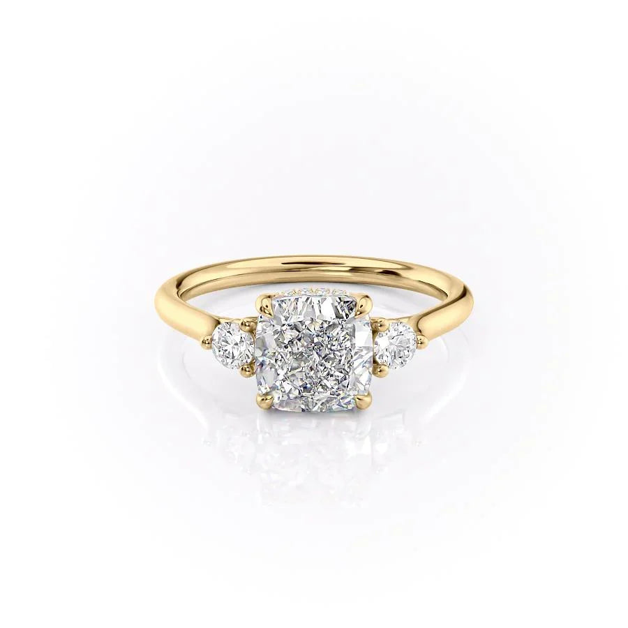 The Lia. A Yellow Gold Three Stone Engagement Ring Set With A 2ct Cushion Lab Grown Diamond. White Background.
