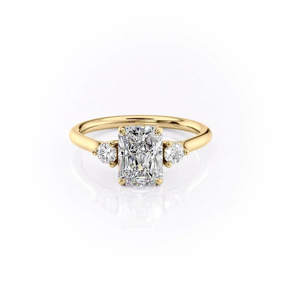 The Lia. A Yellow Gold Three Stone Engagement Ring Set With A 2ct Radiant Lab Grown Diamond. White Background.