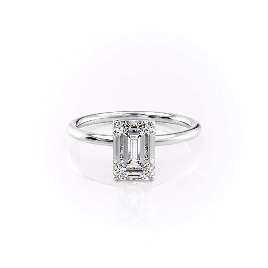 The Lily. A White Gold Solitaire, Nature Engagement Ring Set With A 2ct Emerald Lab Grown Diamond. White Background.