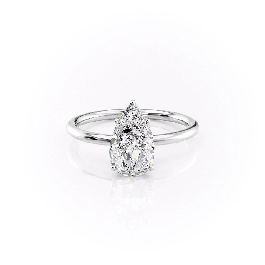 The Lily. A White Gold Solitaire, Nature Engagement Ring Set With A 2ct Pear Lab Grown Diamond. White Background.