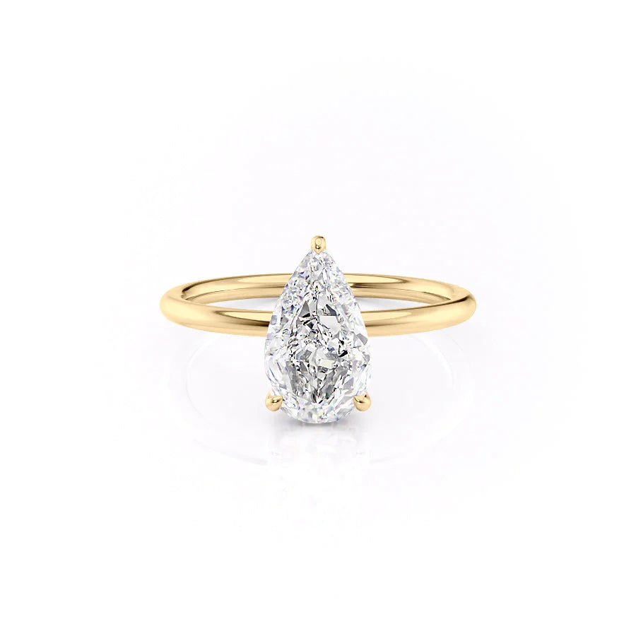 The Low Profile Kamellie. A Yellow Gold Solitaire, Hidden Halo Engagement Ring Set With A 2ct Pear Lab Grown Diamond. White Background.