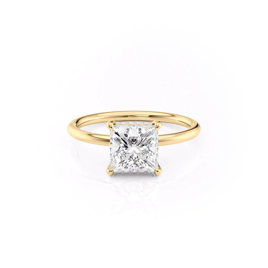 The Low Profile Kamellie. A Yellow Gold Solitaire, Hidden Halo Engagement Ring Set With A 2ct Princess Lab Grown Diamond. White Background.