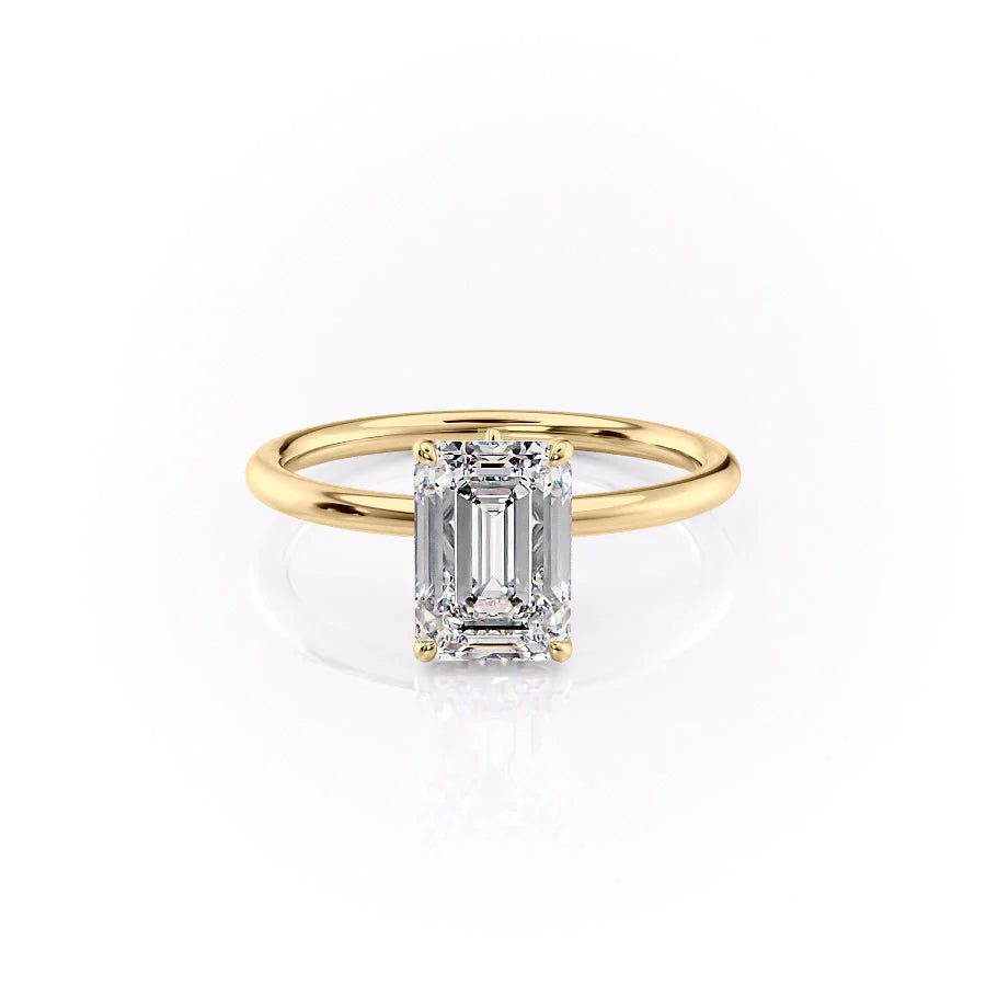 The Luna. A Yellow Gold Solitaire, Nature Engagement Ring Set With A 2ct Emerald Lab Grown Diamond. White Background.