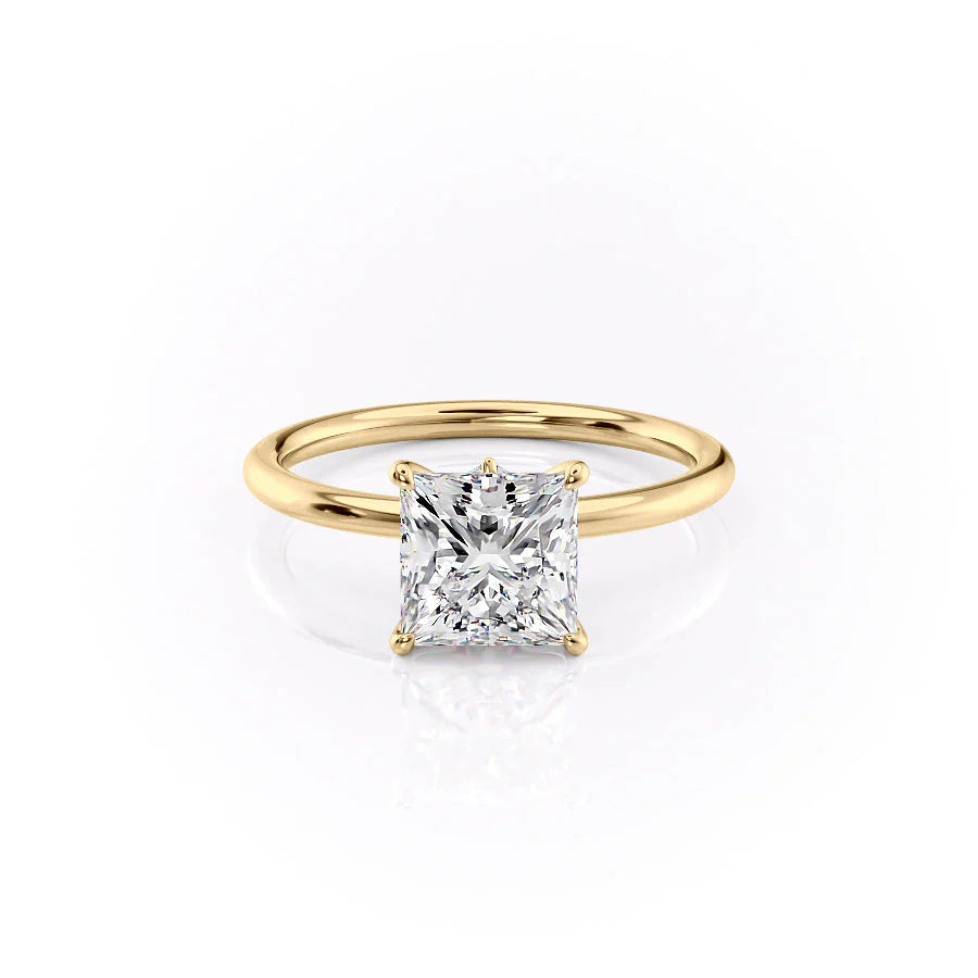 The Luna. A Yellow Gold Solitaire, Nature Engagement Ring Set With A 2ct Princess Lab Grown Diamond. White Background.