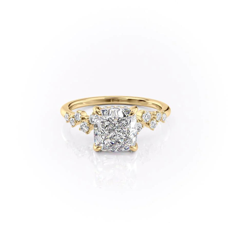The Mia. A Yellow Gold Side Stones, Hidden Halo Engagement Ring Set With A 2ct Cushion Lab Grown Diamond. White Background.