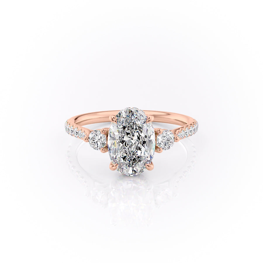 The Pave Lia. A Rose Gold Three Stone Engagement Ring Set With A 2ct Oval Lab Grown Diamond. White Background.