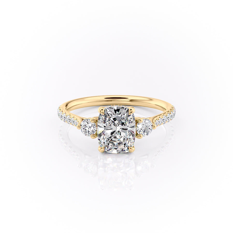 The Pave Lia. A Yellow Gold Three Stone Engagement Ring Set With A 2ct Elongated Cushion Lab Grown Diamond. White Background.