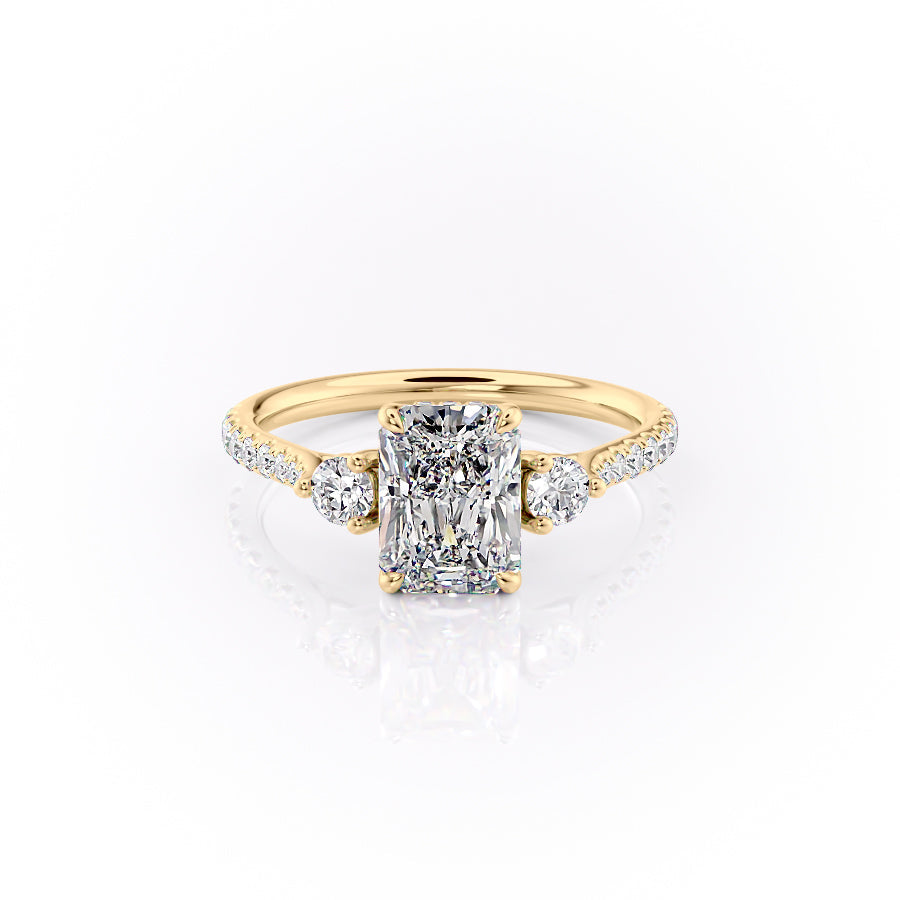 The Pave Lia. A Yellow Gold Three Stone Engagement Ring Set With A 2ct Radiant Lab Grown Diamond. White Background.