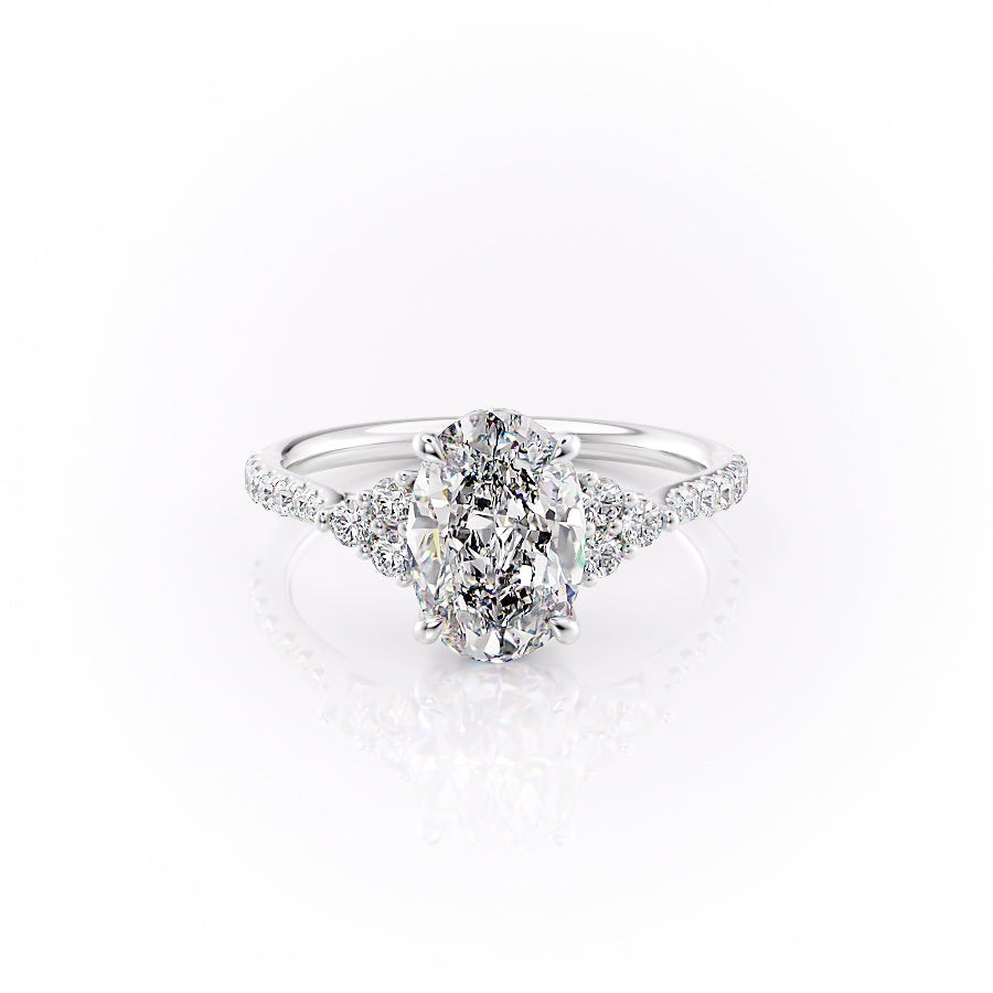 The Pave Scarlett. A White Gold Three Stone, Side Stones Engagement Ring Set With A 2ct Oval Lab Grown Diamond. White Background.