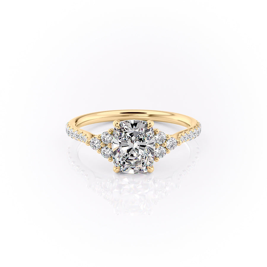The Pave Scarlett. A Yellow Gold Three Stone, Side Stones Engagement Ring Set With A 2ct Elongated Cushion Lab Grown Diamond. White Background.