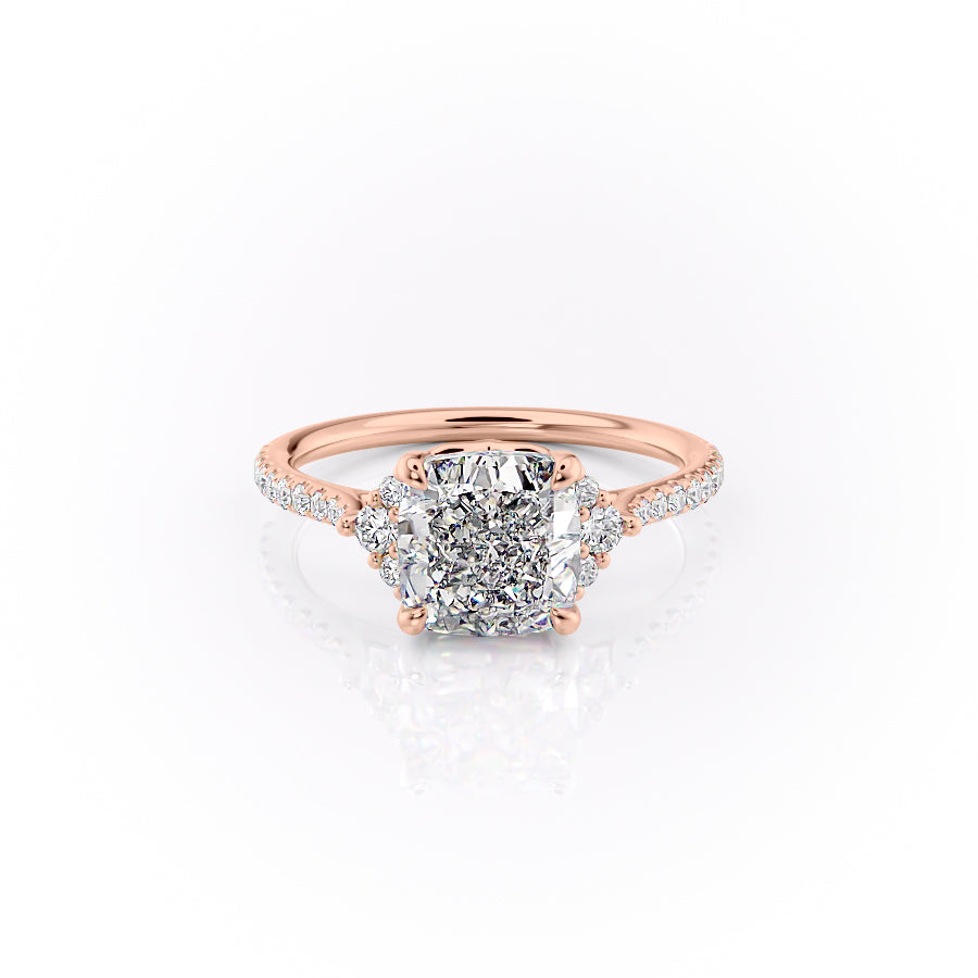 The Pave Victoria. A Rose Gold Three Stone, Side Stones Engagement Ring Set With A 2ct Cushion Lab Grown Diamond. White Background.