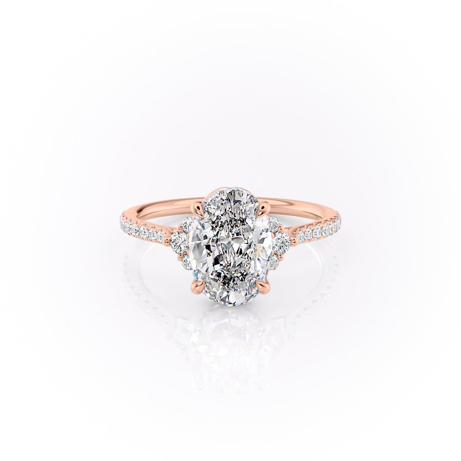 The Pave Victoria. A Rose Gold Three Stone, Side Stones Engagement Ring Set With A 2ct Oval Lab Grown Diamond. White Background.