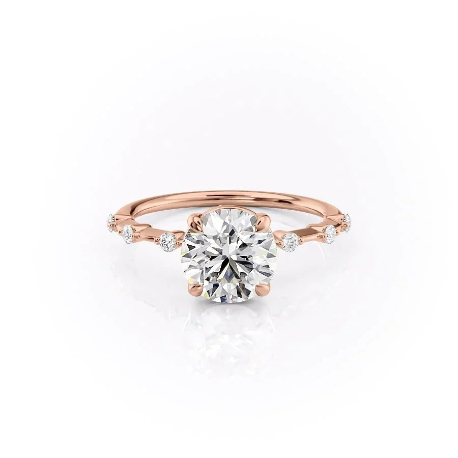 The Penelope. A Rose Gold Solitaire, Side Stones Engagement Ring Set With A 2ct Round Lab Grown Diamond. White Background.