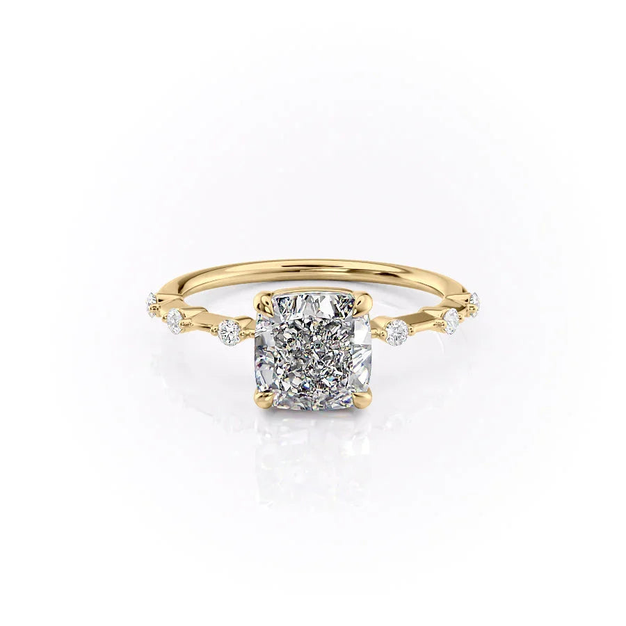 The Penelope. A Yellow Gold Solitaire, Side Stones Engagement Ring Set With A 2ct Cushion Lab Grown Diamond. White Background.