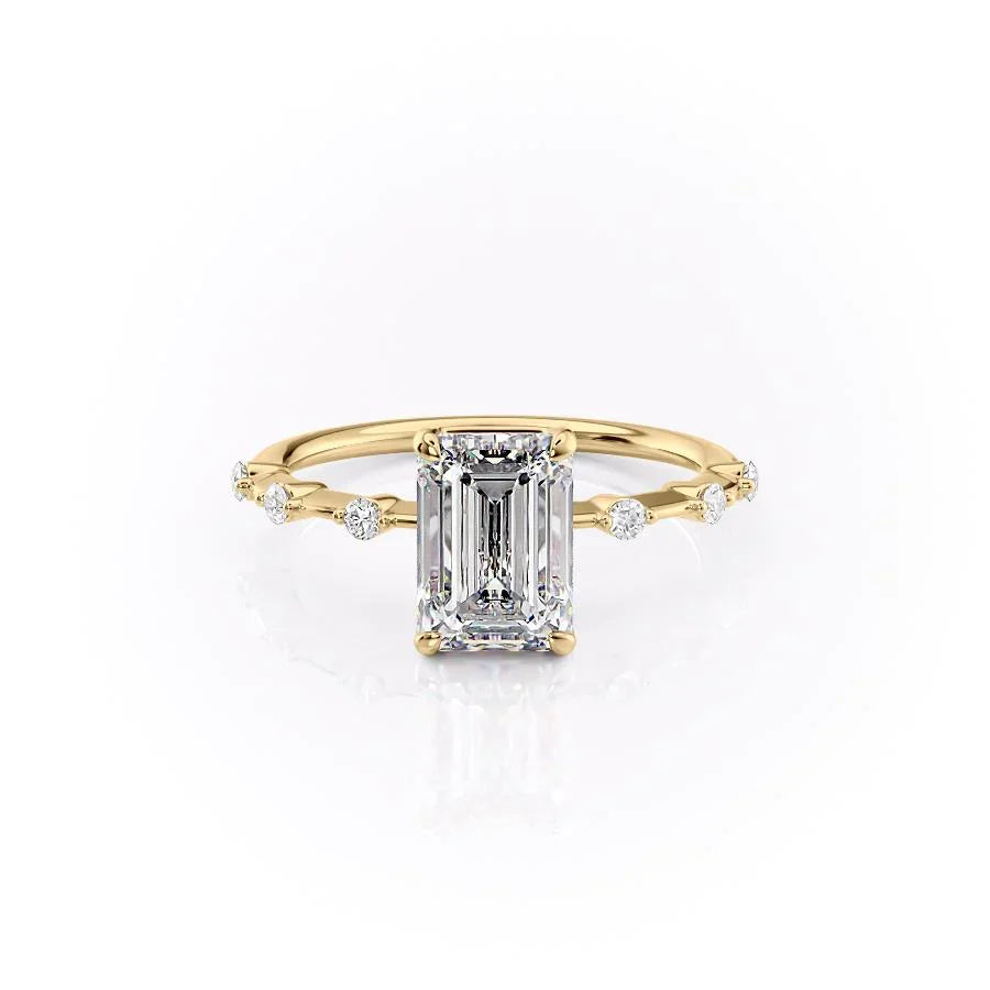 The Penelope. A Yellow Gold Solitaire, Side Stones Engagement Ring Set With A 2ct Emerald Lab Grown Diamond. White Background.