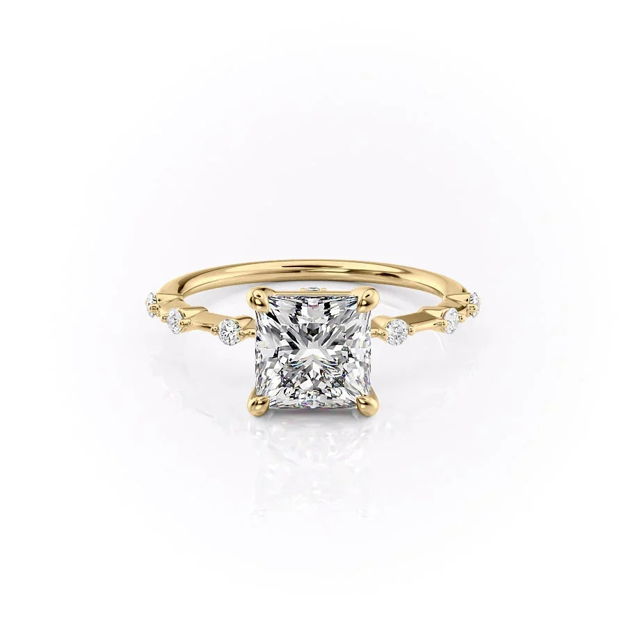 The Penelope. A Yellow Gold Solitaire, Side Stones Engagement Ring Set With A 2ct Princess Lab Grown Diamond. White Background.