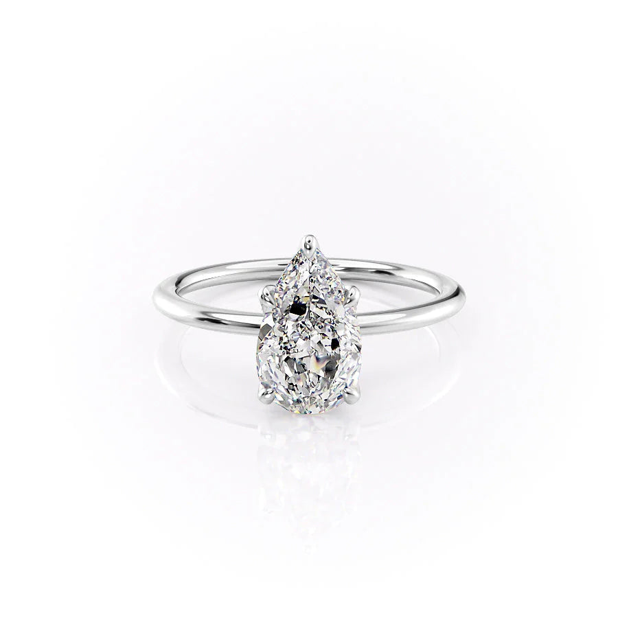 The Petal Kamellie. A White Gold Solitaire, Nature Engagement Ring Set With A 2ct Pear Lab Grown Diamond. White Background.