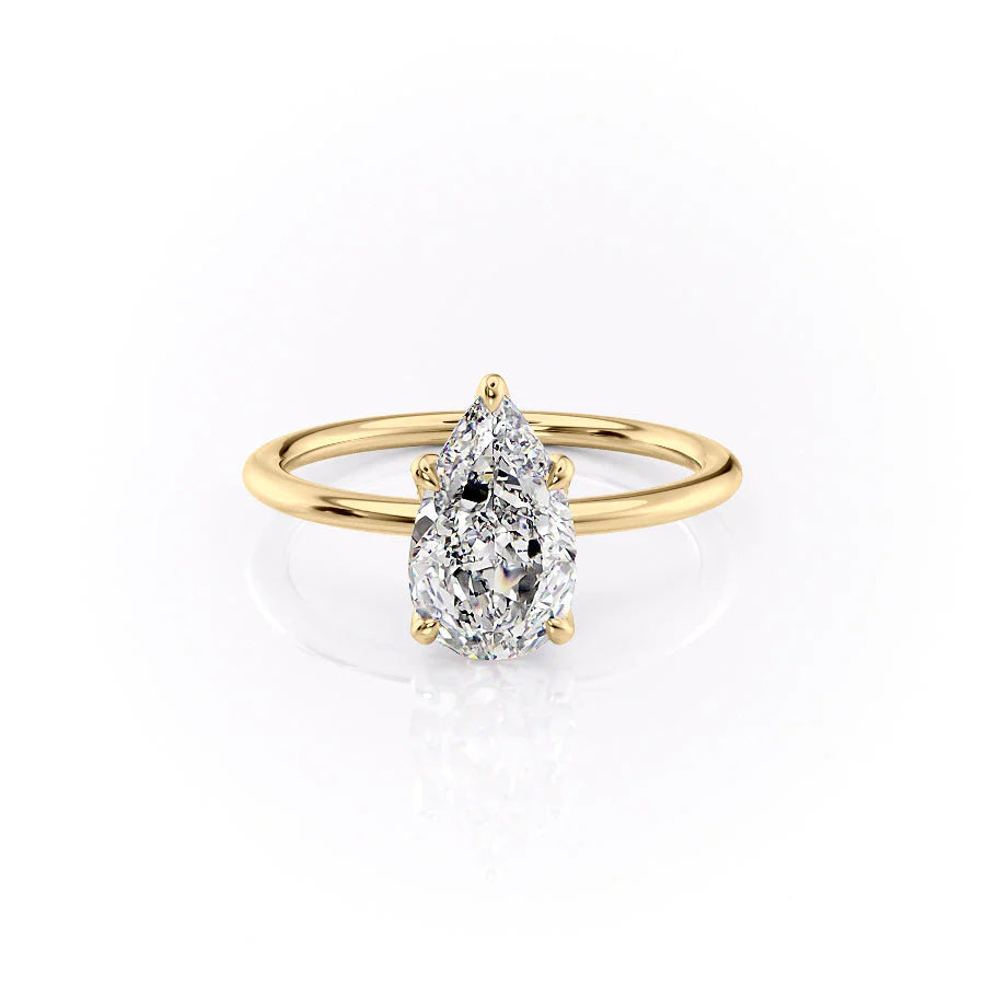 The Petal Kamellie. A Yellow Gold Solitaire, Nature Engagement Ring Set With A 2ct Pear Lab Grown Diamond. White Background.