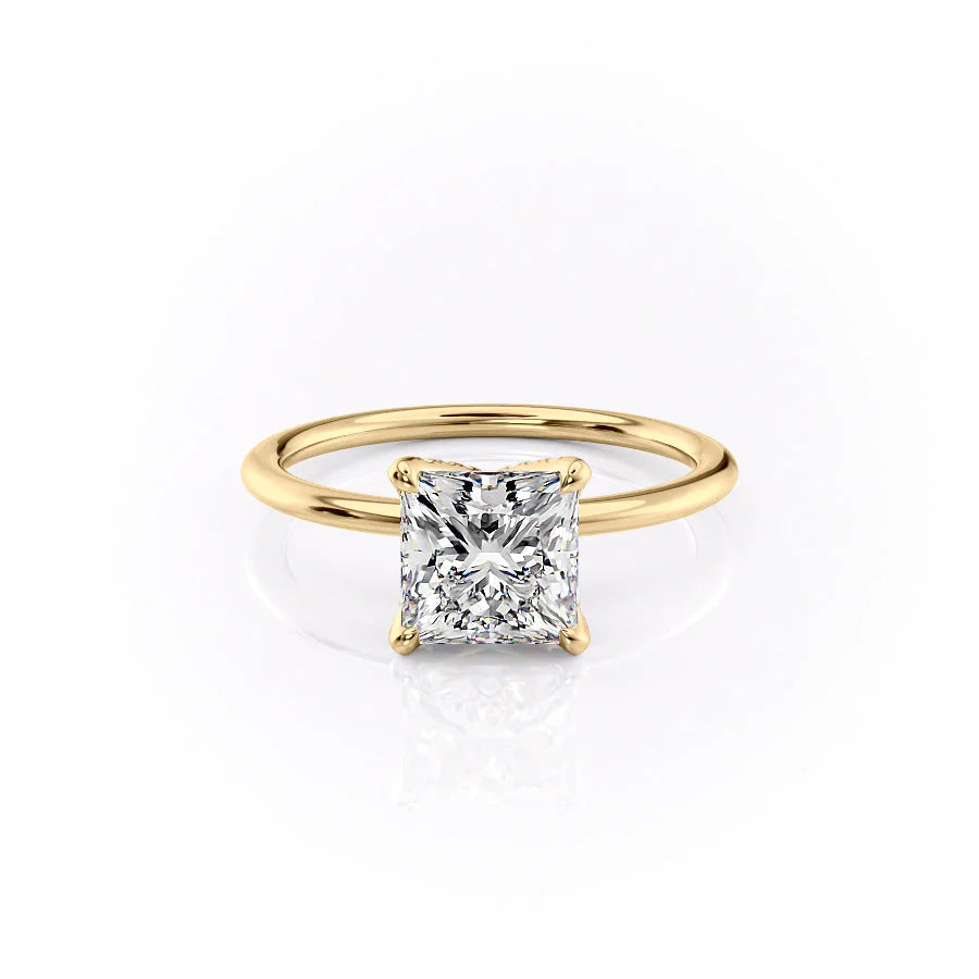 The Petal Kamellie. A Yellow Gold Solitaire, Nature Engagement Ring Set With A 2ct Princess Lab Grown Diamond. White Background.