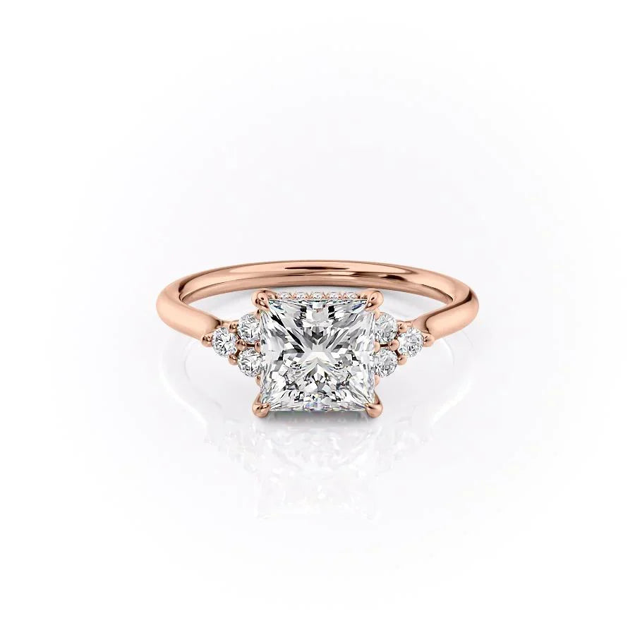 The Scarlett. A Rose Gold Side Stones, Three Stone Engagement Ring Set With A 2ct Princess Lab Grown Diamond. White Background.