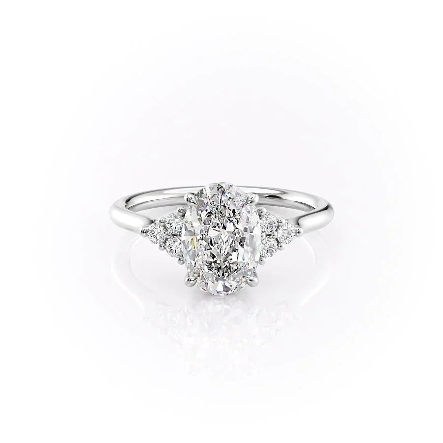 The Scarlett. A White Gold Side Stones, Three Stone Engagement Ring Set With A 2ct Oval Lab Grown Diamond. White Background.