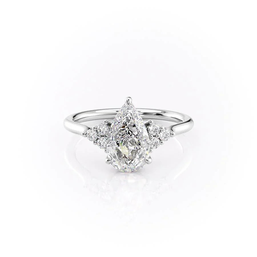 The Scarlett. A White Gold Side Stones, Three Stone Engagement Ring Set With A 2ct Pear Lab Grown Diamond. White Background.