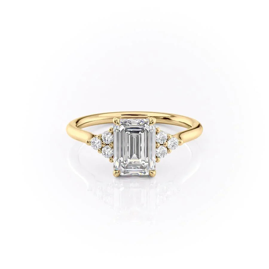 The Scarlett. A Yellow Gold Side Stones, Three Stone Engagement Ring Set With A 2ct Emerald Lab Grown Diamond. White Background.