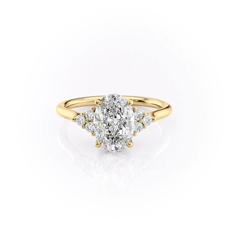The Scarlett. A Yellow Gold Side Stones, Three Stone Engagement Ring Set With A 2ct Oval Lab Grown Diamond. White Background.
