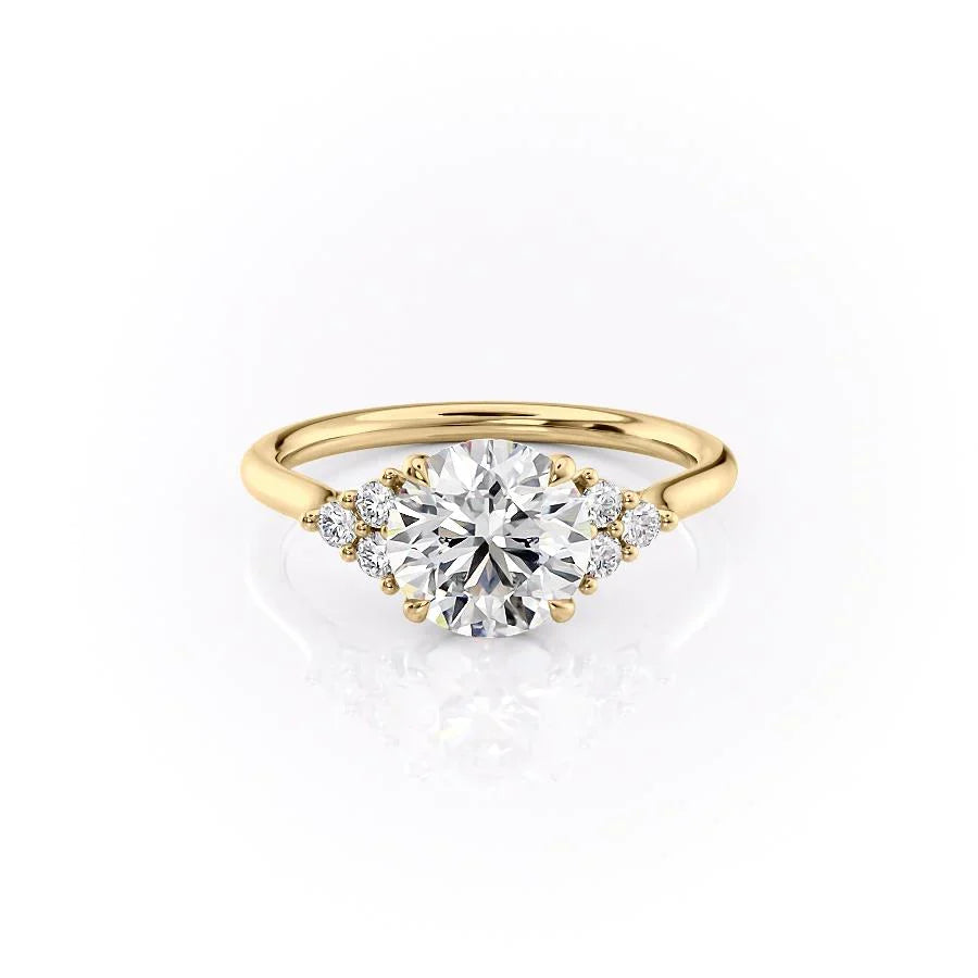 The Scarlett. A Yellow Gold Side Stones, Three Stone Engagement Ring Set With A 2ct Round Lab Grown Diamond. White Background.
