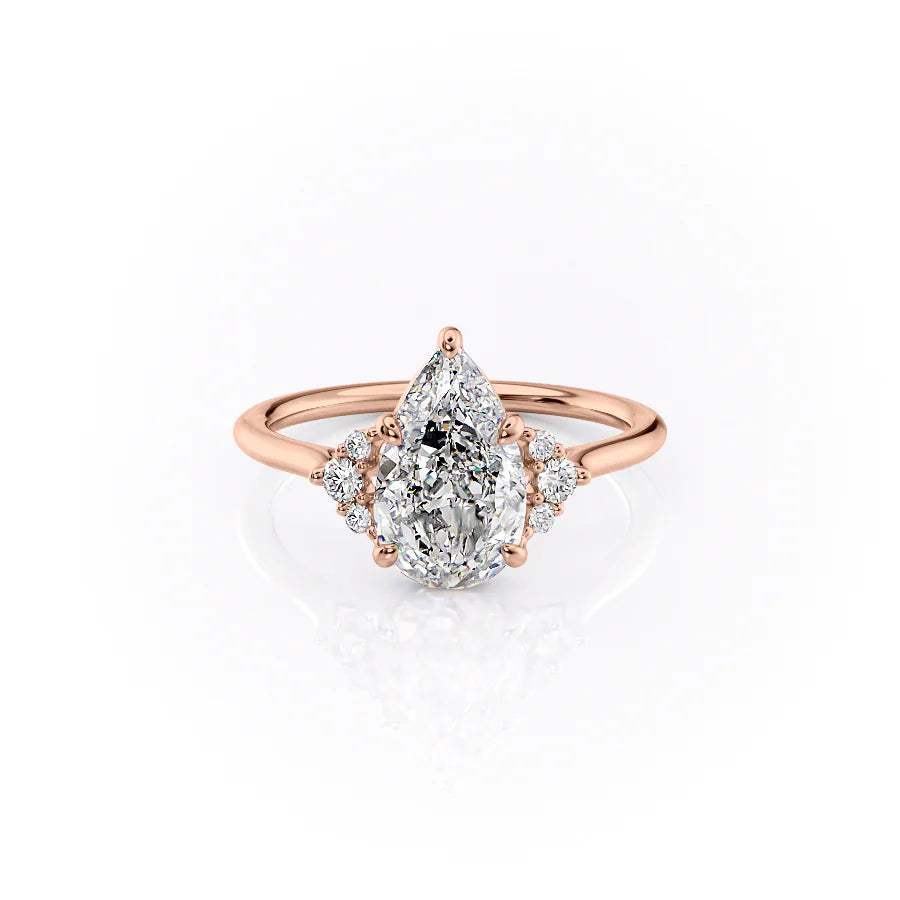 The Victoria. A Rose Gold Three Stone, Side Stones Engagement Ring Set With A 2ct Pear Lab Grown Diamond. White Background.