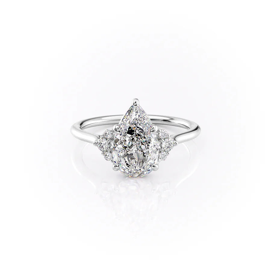 The Victoria. A White Gold Three Stone, Side Stones Engagement Ring Set With A 2ct Pear Lab Grown Diamond. White Background.