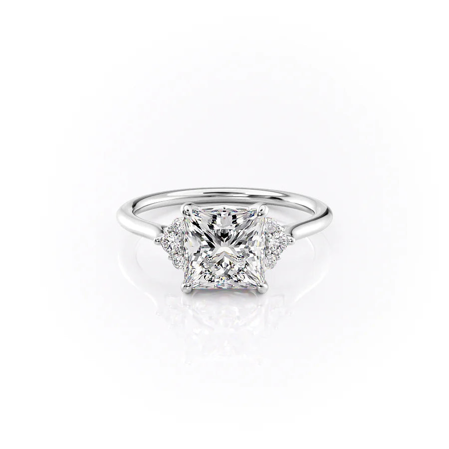 The Victoria. A White Gold Three Stone, Side Stones Engagement Ring Set With A 2ct Princess Lab Grown Diamond. White Background.